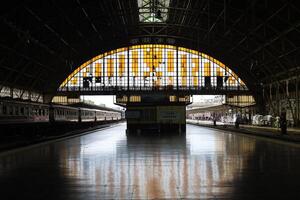 a train station with a large archway and a train photo