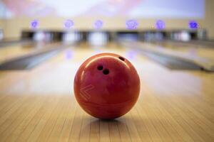 a bowling ball sits on the floor in front of a bowling alley photo