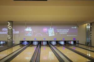 a bowling alley with a large screen showing a game photo