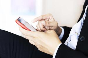 a person in a suit is using a cell phone photo