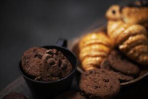 chocolate cookies and croissants on a wooden table photo