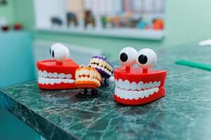 Miniatures of dental artificial jaws with eyes. A plastic model of teeth sits on a table in a dentist's office. photo