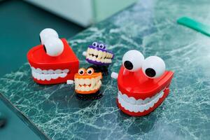 Miniatures of dental artificial jaws with eyes. A plastic model of teeth sits on a table in a dentist's office. photo