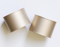 Two empty gold cans on a white surface photo