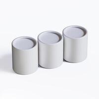 Three white containers with lids on a white surface photo