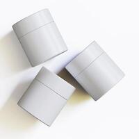 Three white containers with lids on a white surface photo