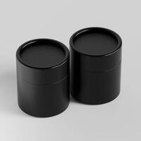 Two black containers with lids on a white surface photo