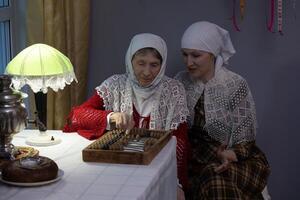 Two women sitting at a table playing a game photo