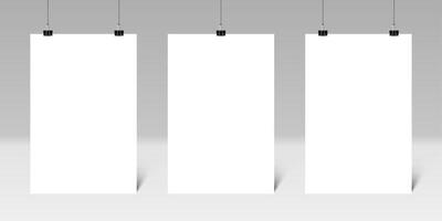Three blank vertical posters hanging from binder clips on a gray wall create an ideal setting for displaying artwork or designs, enhancing any creative environment or presentation space vector
