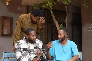 three students standing together in a school courtyard. They are engaged with their smart phones, absorbed in their devices. photo