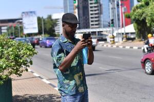 Happy hipster man using smart phone at street photo