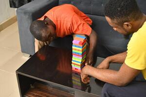 A warm and engaging scene of an amputee man and his friend enjoying a Board game with wooden bricks. Jenga game, wooden tower photo