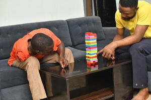 A warm and engaging scene of an amputee man and his friend enjoying a Board game with wooden bricks. Jenga game, wooden tower photo