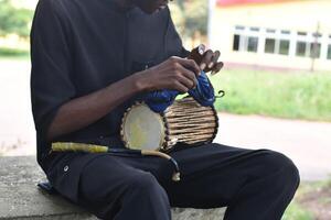 image of a Man playing the talking drum photo