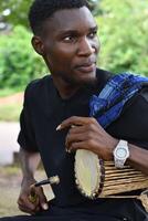 image of a Man playing the talking drum photo