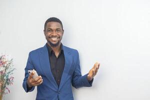 portrait of cheerful young black guy sending message on mobile phone. Happy African-American man using smartphone, enjoying chatting online, messaging in social networks photo
