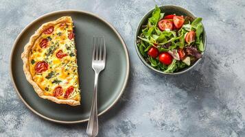 Plate with quiche slice, small salad bowl, and fork on the side, food photography photo