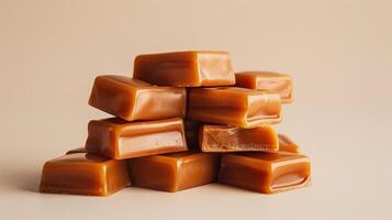 Pile of caramel candies stacked in a heap, highlighting their rectangular shapes on a neutral backdrop, gastronomy photography photo