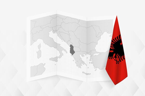A grayscale map of Albania with a hanging Albanian flag on one side. Map for many types of news.