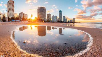 serene beach sunset reflecting in puddle, with city skyline. warm colors of sunset create tranquil atmosphere, perfect for relaxation and contemplation photo