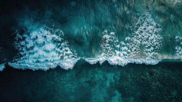 An aerial view of waves crashing into the ocean photo