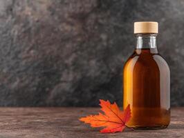 Autumn maple leaf and maple syrup bottle photo
