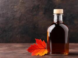 Autumn maple leaf and maple syrup bottle photo