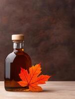 Maple syrup bottle with autumn leaf photo