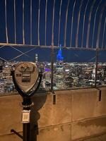 A coin operated binoculars on top of a building overlooking the city photo