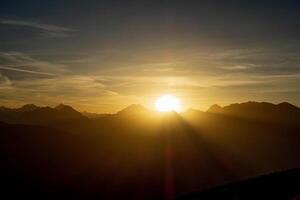 The sun is setting over the mountains in this photo