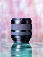 Close up of a professional camera lens on a reflective surface photo