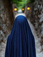 mysterious figure in blue cloth walking down a path photo