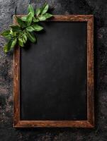 Rustic wooden frame with fresh bay leaves on dark slate background photo