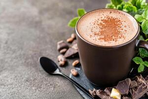 Indulge in a rich steaming mug of hot chocolate topped with caramel foam, surrounded by cocoa beans and dark chocolate on a rustic surface photo