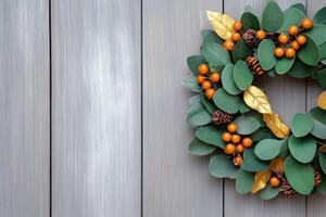 Handmade wreath with golden leaves and terracotta berries hanging on a rustic wooden door in warm autumn tones photo