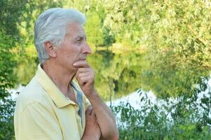 Close up portrait of thinking senior man in park photo
