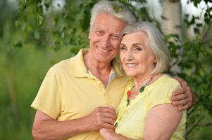 Beautiful senior couple posing and hugging in the park photo