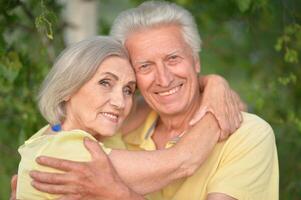 Beautiful senior couple posing and hugging in the park photo