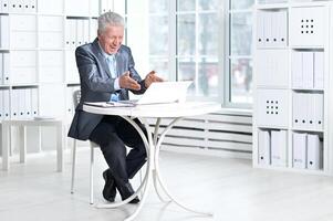 Senior businessman working with computer in office photo