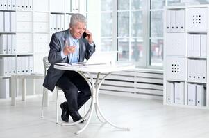 Senior businessman working with computer in office photo