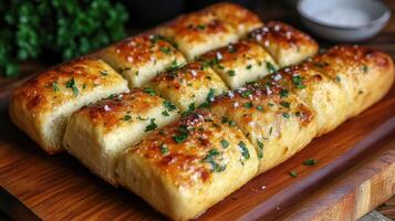 Delicious homemade garlic knots sprinkled with parsley and salt on wooden board photo