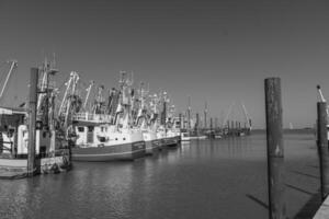 A black and white photo of a dock with boats