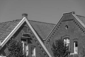 A black and white photo of a house with a clock on it