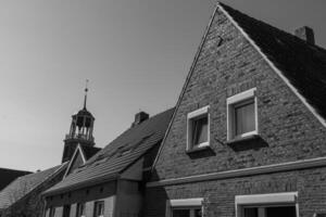 A black and white photo of a clock tower and a building