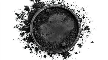 Black powder in a round container. Concept of Cosmetics, Charcoal, Pigment photo