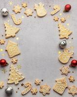 Christmas gingerbread cookies and ornaments creating festive frame on grey background photo