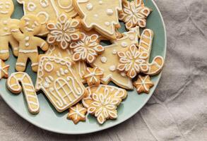 Christmas cookies with white icing forming various shapes lying on a plate photo
