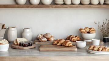 A counter with a bunch of croissants and other food photo