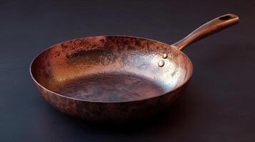 A copper frying pan on a black surface photo