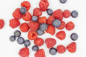 fresh forest blueberry and raspberry isolated on white background, top view. Fresh ripe berry on a white background. photo